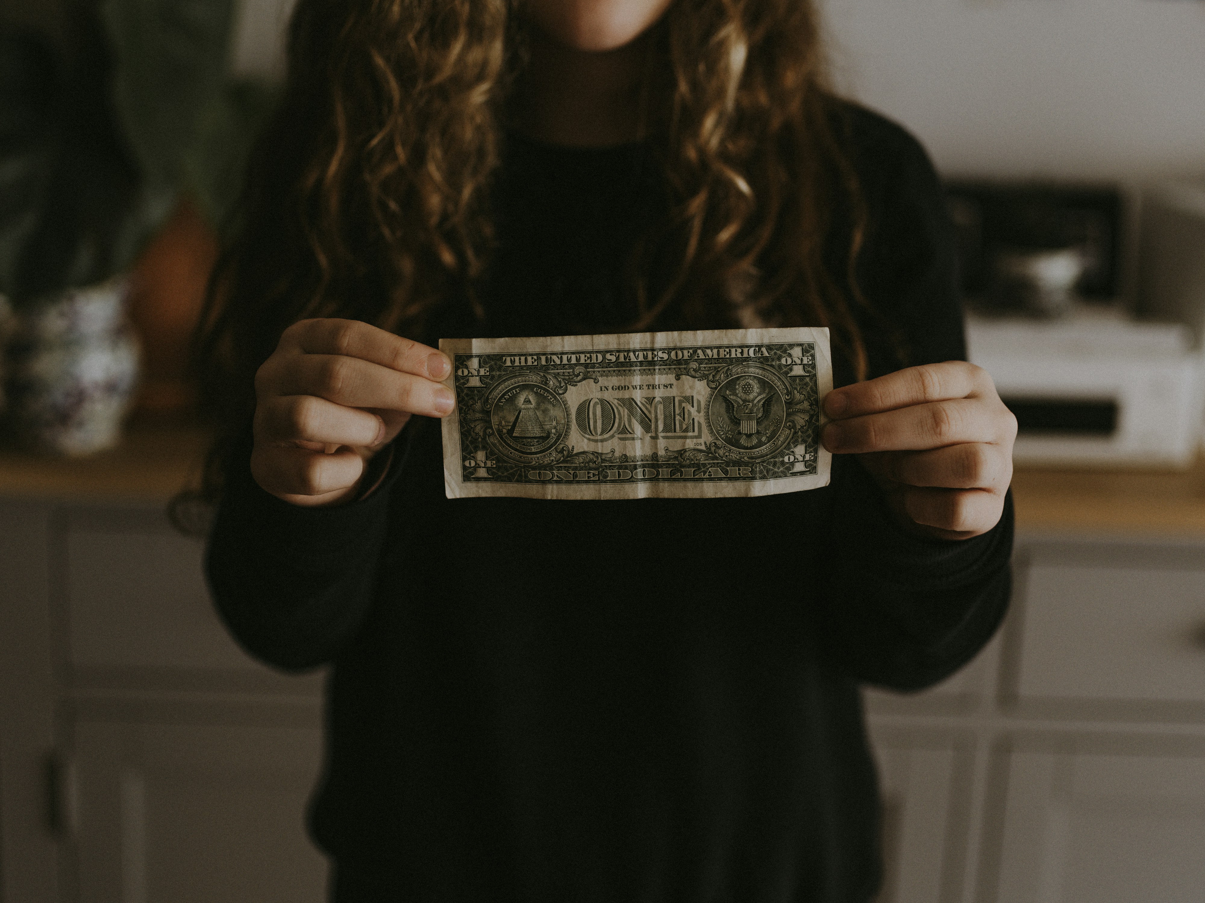 Person holding a one dollar billby Annie Spratt